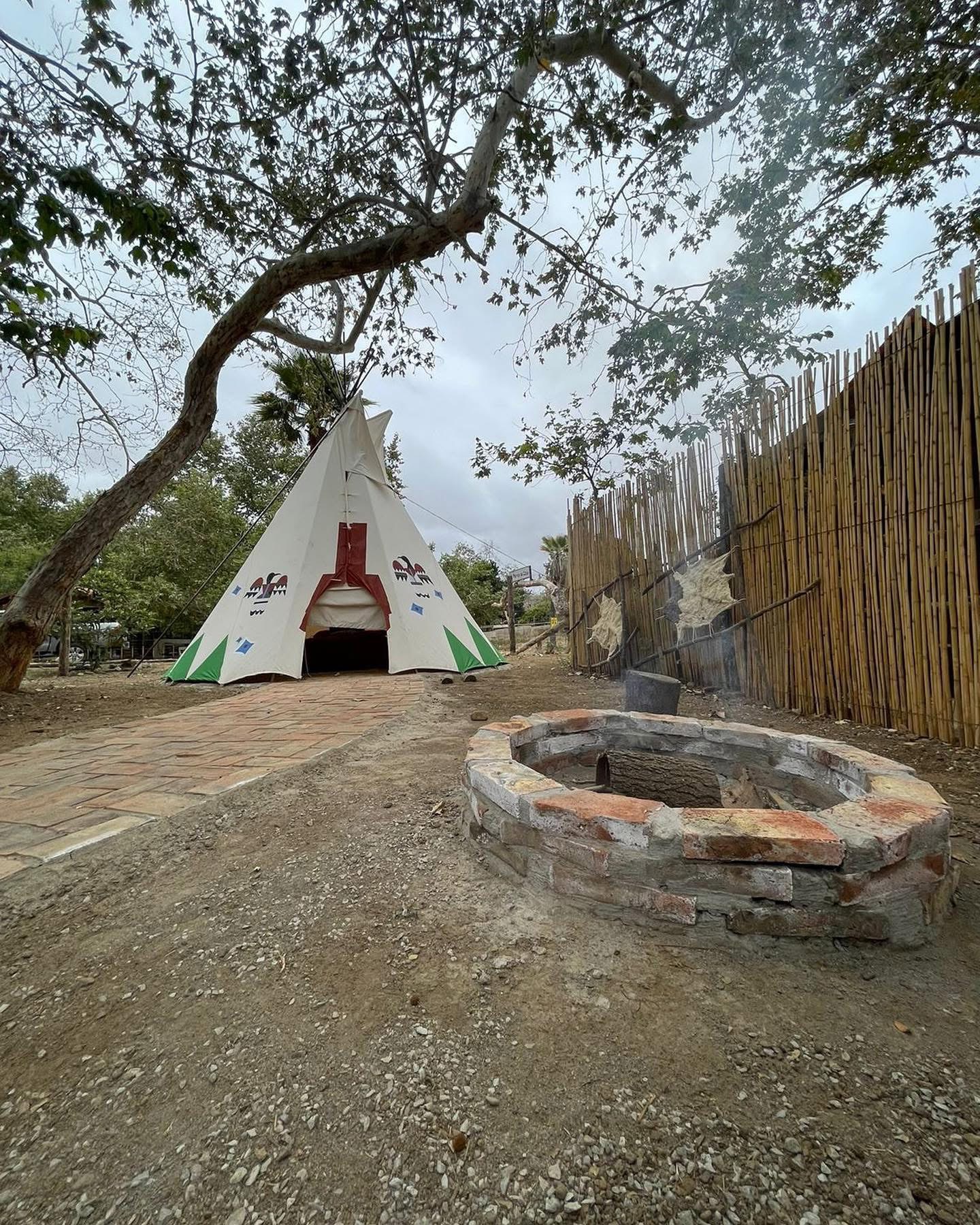 Tipi y fogatero en el bosque del paraje